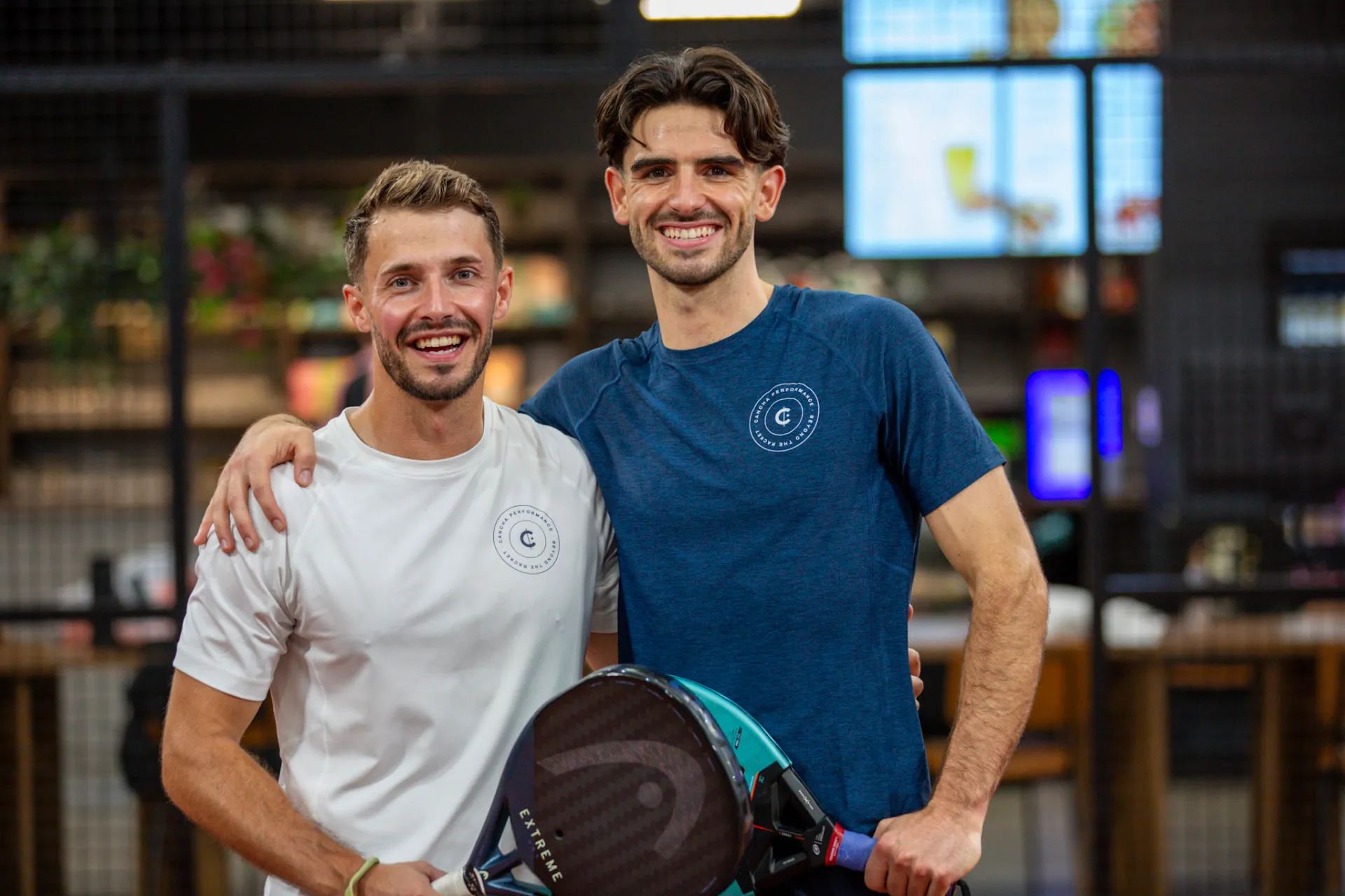 Coaches Steve and Kyle smiling together at a padel club